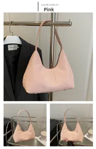 Detail of pink faux snakeskin crescent hobo bag featuring smooth texture and metal studs