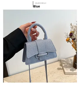 Détail d'un mini sac bandoulière bleu avec texture tissée diagonale et poignée supérieure