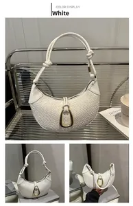 Detail of white woven hobo bag featuring a gold U-shaped buckle and knotted strap design