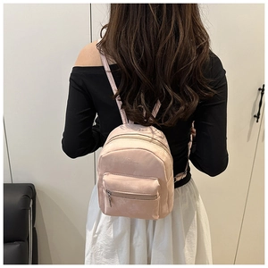 Dettaglio del mini zaino rosa con trama in pelle scamosciata e logo in rilievo