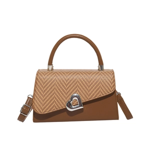 Brown leather handbag with woven flap, heart-shaped metal buckle and adjustable strap