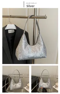 Macro detail of silver snake embossed texture and metallic finish on shoulder bag