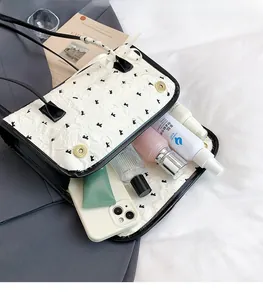 Detailed interior view of quilted white handbag with black bows and magnetic gold buckle