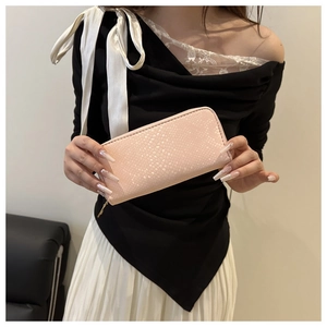 Detail of pink long wallet featuring snake texture embossing and gold metal zipper