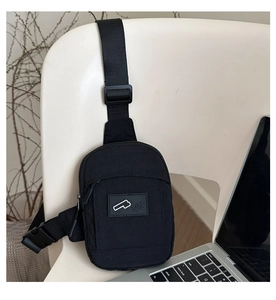 Detail of black nylon crossbody bag featuring a durable buckle and adjustable strap