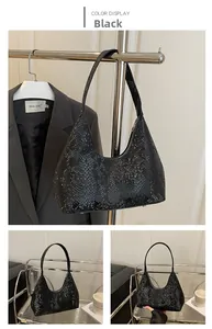 Close-up of black snake-embossed hobo bag with glossy finish and silver-tone hardware