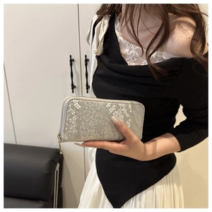 Detail of silver long wallet featuring embossed snakeskin texture and golden zipper