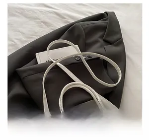 Detail showing the white crocodile pattern texture and adjustable strap on the bucket bag