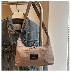 Detail of adjustable strap and nylon texture on light coffee hobo shoulder bag