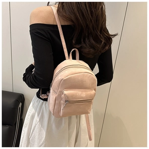 Detailansicht eines rosa PU-Lederrucksacks mit Logo-Prägung und vorderer Reißverschlusstasche