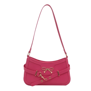 Hot pink shoulder bag with gold metal bow and grommet strap in a trendy Y2K style