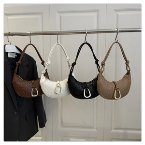 Detailed woven texture of crescent shoulder bags with gold U-shaped metal buckle accents