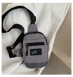 Détail du sac de poitrine gris en nylon imperméable avec sangle réglable et étiquette