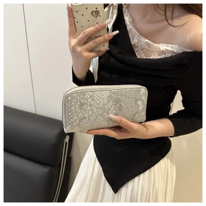Close-up of silver snakeskin textured women's long wallet with metallic zipper detail