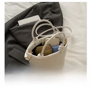 Detail shot showing the large interior capacity of this white bucket bag with a knotted handle