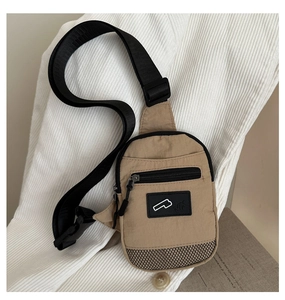 Détail du sac de poitrine en nylon kaki montrant la structure multi-poches et le mesh