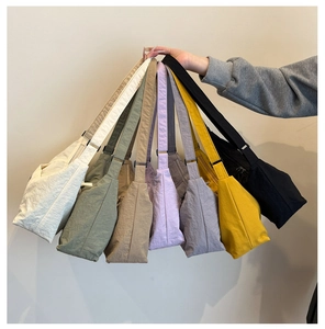 Assorted colors of nylon crescent shoulder bags with adjustable straps shown in detail