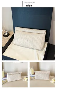 Detail of beige woven clutch bag in luxury black gift box with lifestyle decor