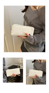 Detail of white faux snake pattern wallet with premium golden zipper texture