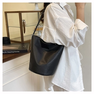 Detail of black lychee grain leather bucket bag with silver chain and shoulder strap