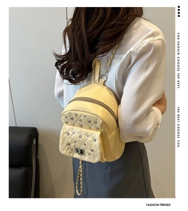 Makroaufnahme der cremefarbenen gesteppten Mini-Beuteltasche mit silbernen Nieten-Details