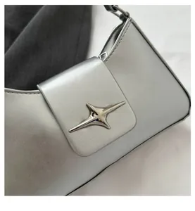 Detailed macro view of the silver metallic shoulder bag featuring a star metal clasp