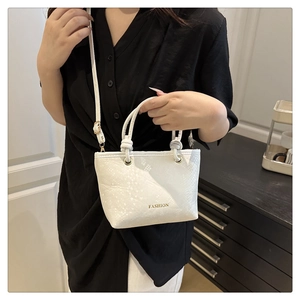 Close-up of white fashion handbag with leather texture and stylish FASHION lettering