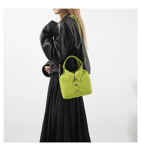 Detalle del bolso verde lima con forma de camisa, botones y textura de cuero de grano