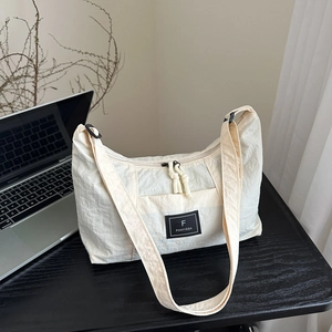 Minimalist beige oversized nylon crescent tote bag for casual daily commute wear