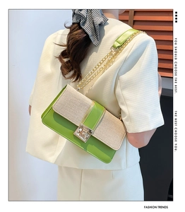 Detail of green faux leather and straw patchwork crossbody bag with gold chain strap
