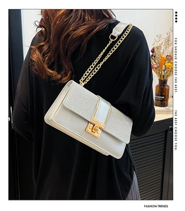 Chic silver patchwork chain bag with golden swivel lock worn on shoulder for style