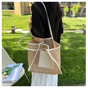 Close-up of woven straw tote bag featuring white leather trim and fashion lettering