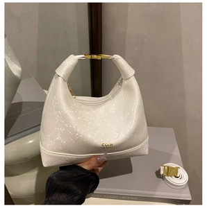Detail of white crocodile texture handbag with gold COIH logo and adjustable shoulder strap