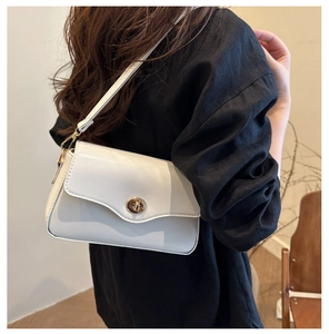 Détail du fermoir pivotant doré et du cuir mat de haute qualité du sac à rabat blanc