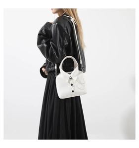 Detalle del bolso blanco con forma de camisa con cuello y botones tipo bandolera