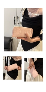 Detail of pink long clutch wallet featuring subtle snakeskin texture and gold zipper closure