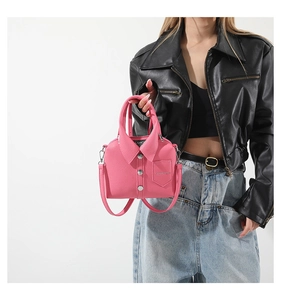 Detalle de bolso rosa con diseño de chaqueta con solapas y botones metálicos