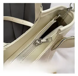 Détails de la fermeture éclair argentée sur le sac seau tissé de couleur crème