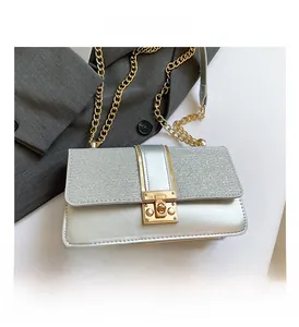 Detail of silver flap bag with glitter finish and chunky gold chain strap