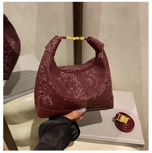 Close-up of wine red snake pattern handbag featuring gold hardware and strap