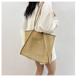 Close-up of woven straw tote bag with brown leather patch on white top background