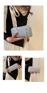 Detail of silver snake skin texture on long wallet with metallic finish and gold zipper