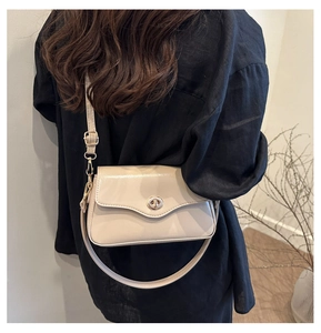 Détail du sac à bandoulière beige chic avec boucle dorée et bandoulière réglable
