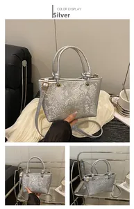 Close-up of silver snakeskin leather texture with gold Fashion lettering and metal buckles
