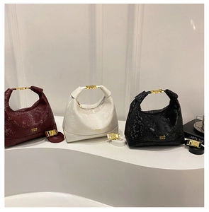 Detailed close-up of snake embossed leather handbags in red, white, and black colors