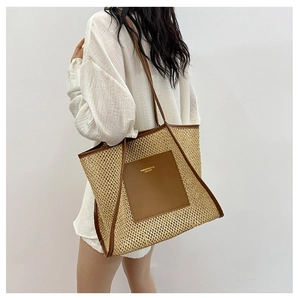 Detail of woven straw tote bag with brown leather handles and square front pocket