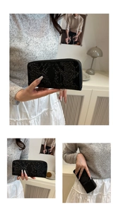 Close-up of black snake-embossed long wallet with metallic zipper in a minimal setting
