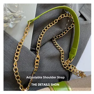 Detail of adjustable green leather strap with gold metal chain on a woven shoulder bag