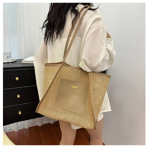 Detail of woven straw tote bag with khaki faux leather pockets and brand logo lettering