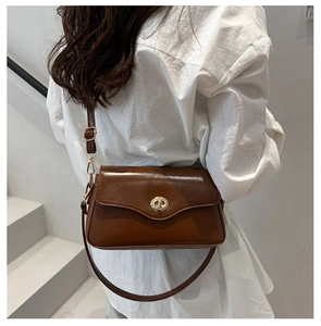 Brown faux leather shoulder bag featuring a sleek vintage design and gold oval metal twist lock